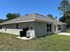 The back of a single-story home with a well-manicured lawn and an outdoor utility setup at 4012 Oscar Ter, North Port, FL 34286