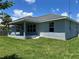 Well-maintained home featuring a covered patio, lush lawn, and a recently painted exterior at 4860 Florida Rd, Venice, FL 34293
