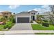 Modern house exterior with a dark gray garage door and landscaping at 5244 Barnett Cir, Lakewood Ranch, FL 34211