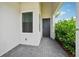 Side porch entry with gray pavers and a dark door at 5244 Barnett Cir, Lakewood Ranch, FL 34211