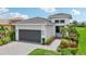Modern house exterior with a dark gray garage door and landscaping at 5244 Barnett Cir, Lakewood Ranch, FL 34211