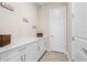 Bright laundry room with white cabinets and quartz countertops at 6600 Dovekey Dr, Sarasota, FL 34241