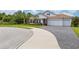 Two-car garage and a paved driveway, nicely landscaped front yard at 6600 Dovekey Dr, Sarasota, FL 34241