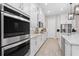 Bright kitchen featuring stainless steel double ovens and white cabinets at 6600 Dovekey Dr, Sarasota, FL 34241