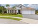 Two-story house with a three-car garage and lush landscaping at 6600 Dovekey Dr, Sarasota, FL 34241