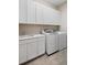 Laundry room with washer, dryer, and white cabinets at 6600 Dovekey Dr, Sarasota, FL 34241