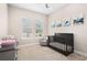 Bedroom featuring crib, armchair, and plenty of natural light at 6600 Dovekey Dr, Sarasota, FL 34241