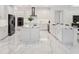 Modern kitchen with white cabinets, large island, and marble floors at 3582 Recurve Cir, Sarasota, FL 34240