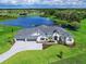 Luxury home with lake view, stone driveway, and lush landscaping at 3582 Recurve Cir, Sarasota, FL 34240