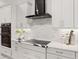 Modern kitchen with white cabinets, quartz countertops and a black range hood at 3582 Recurve Cir, Sarasota, FL 34240