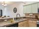 Kitchen with light green cabinets, granite countertops, and a double sink at 5635 Spanish Point Ct, Palmetto, FL 34221