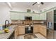 Kitchen with light green cabinets and stainless steel appliances at 5635 Spanish Point Ct, Palmetto, FL 34221