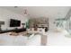 Open living room with white couches and large TV, flows into kitchen and dining area at 107 Elm Ave, Anna Maria, FL 34216