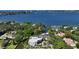 Aerial view of a modern waterfront home surrounded by lush greenery, offering a private and scenic escape at 1610 N Lodge Dr, Sarasota, FL 34239