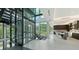 Bright, modern foyer with a glass-enclosed elevator, sleek staircase, and views to the modern kitchen at 1610 N Lodge Dr, Sarasota, FL 34239