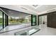 Expansive living room with modern furniture, floor-to-ceiling windows, and an outdoor dining area at 1610 N Lodge Dr, Sarasota, FL 34239