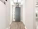 Welcoming entryway with a stylish gray door, wood-look tile floors, and a modern light fixture at 2105 Sylvan Lea Dr, Sarasota, FL 34240