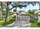 Attractive home with a three-car garage, paved driveway, and lush landscaping at 2105 Sylvan Lea Dr, Sarasota, FL 34240