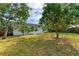 House with a fenced backyard, featuring lush green grass and mature trees at 818 Padgett Ave, Sarasota, FL 34237