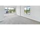 Bright bedroom with grey carpet and large windows with street view at 2955 N Beach Rd # A531, Englewood, FL 34223