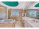 Elegant bathroom with double vanity, large tub, and glass block feature wall at 5444 Gulf Of Mexico Dr, Longboat Key, FL 34228
