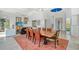 Open dining room with a large wooden table and orange chairs at 5444 Gulf Of Mexico Dr, Longboat Key, FL 34228
