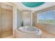 Relaxing bathroom with heart-shaped tub and glass block wall at 5444 Gulf Of Mexico Dr, Longboat Key, FL 34228
