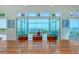 Waterfront dining area with large wooden table, red chairs and access to patio at 5444 Gulf Of Mexico Dr, Longboat Key, FL 34228