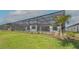 Spacious backyard with lawn, landscaping, and screened pool and lanai at 10629 Nicklaus Ct, Englewood, FL 34223