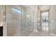 New bathroom with a glass shower door and marble tiling at 10629 Nicklaus Ct, Englewood, FL 34223