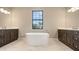 Bright bathroom featuring double vanities and a soaking tub at 10629 Nicklaus Ct, Englewood, FL 34223