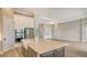 Gourmet kitchen and living room featuring a large island, white cabinets, and stainless steel appliances at 10629 Nicklaus Ct, Englewood, FL 34223