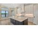 Gourmet kitchen featuring a large island, white cabinets, and stainless steel appliances at 10629 Nicklaus Ct, Englewood, FL 34223