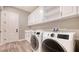 Functional laundry room with modern washer, dryer, sink, and ample storage at 10629 Nicklaus Ct, Englewood, FL 34223