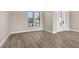 Neutral living space enhanced by wood-look floors, large windows and a view to the exterior at 10629 Nicklaus Ct, Englewood, FL 34223