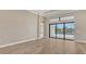 Bright and airy living room featuring wood floors and a large sliding glass door with a view of the pool at 10629 Nicklaus Ct, Englewood, FL 34223