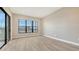 Bright living room featuring wood-look tile flooring, large windows, and neutral wall paint at 10629 Nicklaus Ct, Englewood, FL 34223