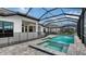 Private screened-in pool and spa surrounded by a brick-paver patio and a safety fence at 10629 Nicklaus Ct, Englewood, FL 34223