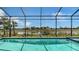 Screened-in pool boasts a stunning view of the lake with tropical foliage at 10629 Nicklaus Ct, Englewood, FL 34223