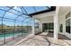 Inviting outdoor living space with a screened-in pool, brick pavers, and a beautiful lake view at 10629 Nicklaus Ct, Englewood, FL 34223