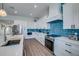 Bright kitchen with white cabinets, blue tile backsplash, and stainless steel appliances at 2102 Avenue B, Bradenton Beach, FL 34217