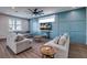 Living room with gray sofas, wood coffee tables, and a blue accent wall at 2102 Avenue B, Bradenton Beach, FL 34217