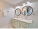 Guest bathroom with double vanity, granite countertop and circular mirrors at 2102 Avenue B, Bradenton Beach, FL 34217