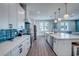 Modern kitchen featuring white cabinets, blue tile backsplash, and stainless steel appliances at 2102 Avenue B, Bradenton Beach, FL 34217
