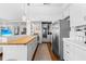 White kitchen with stainless steel appliances and wood flooring at 750 Penfield St, Longboat Key, FL 34228