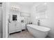 Elegant bathroom with soaking tub, vanity, and tiled floors at 750 Penfield St, Longboat Key, FL 34228