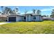 Single-story home with dark gray garage door and green lawn at 2017 Lovoy Ct, North Port, FL 34288