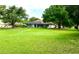 Large grassy backyard with mature trees and a view of the home at 623 147Th E St, Bradenton, FL 34212