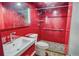 Modern bathroom with red walls, walk-in shower, and grab bars at 1350 N Portofino Dr # 310, Sarasota, FL 34242