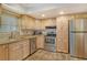 Kitchen with light wood cabinets, stainless steel appliances, and granite countertops at 1350 N Portofino Dr # 310, Sarasota, FL 34242